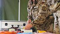 Ein Soldat zählt elektronisches Gerät auf einem Tisch