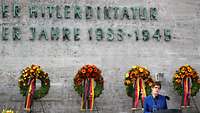 Annegret Kramp-Karrenbauer steht am Rednerpult vor Gedenktafel in der Gedenkstätte Plötzensee