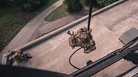 Ein KSK-Soldaten seilt sich aus einem Hubschauber auf das Dach eines Gebäudes ab.