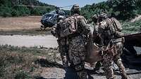 KSK-Soldaten tragen einen Verwundeten in einem Tragetuch zu einem Hubschrauber.