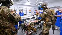 KSK-Soldaten und medizinisches Personal stehen im Schockraum um einen verletzten Soldaten