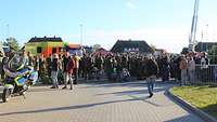 Viele Menschen, die meisten in Bundeswehruniform, stehen auf einem Platz. Im Hintergrund mehrere Blaulichtfahrzeuge.