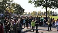 Hunderte Menschen wandern auf einer Straße in der Evenburg-Kaserne.