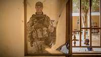 Ein Soldat steht in Uniform vor einem Spiegel und fotografiert sich selbst