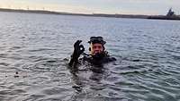 Fregattenkapitän Boris M. schwimmt im Taucheranzug an der Wasseroberfläche.