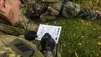 Ein Soldat macht sich auf einem Blatt Notizen.