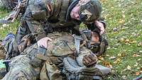 Ein Soldat kontrolliert bei einem Kameraden die Atmung.