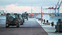Mehrere Einsatzfahrzeuge vom Typ Eagle fahren auf dem Pier entlang der Kaimauer.