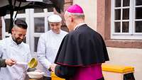 Militärbischof Overbeck bekommt einen Teller Erbsensuppe aus der Feldküche