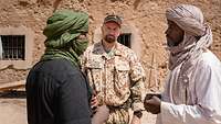 Ein deutscher Soldat und zwei Malier unterhalten sich