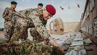 Ein Soldat legt eine Münze auf eine kleine Gedenktafel in Afghanistan