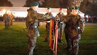 Soldaten legen mit der Hand an der Truppenfahne ihren Eid ab.