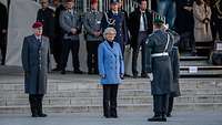 Ein Soldat grüßt Ministerin Lambrecht, Generalinspekteur Zorn steht daneben. Im Hintergrund Zuschauer auf einer Tribüne.