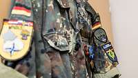 Die alte Uniform hängt am Schrank. Darauf sind verschiedene Patches, wie beispielsweise vom Kosovo-Einsatz