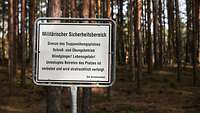 Ein Schild mit der Aufschrift „Militärischer Sicherheitsbereich“ steht in einem Wald
