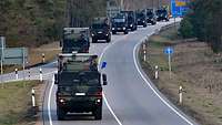 Eine Marscheinheit der Bundeswehr fährt über eine Landstraße.