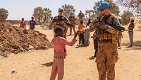 Soldaten auf Patrouille im Gespräch mit Kinder