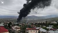 In Stepanakert, die Hauptstadt der Republik Arzach, Aserbaidschan, steigt schwarzer Rauch in einer Wohngegend auf.