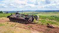 A DACHS armoured engineer vehicle pulls a drag along for landscape maintenance.