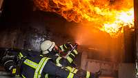 Two female firefighters extinguish a ceiling fire