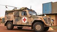 Ein Fahrzeug vom Typ Eagle IV mit rotem Kreuz und UN-Schriftzug auf der Karosserie steht im Camp Castor.