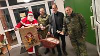 Der Nikolaus und Militärpfarrer Pater Roman Fries übergeben an Soldaten eine Nikolaus Überraschung