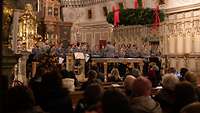 Musiker und Musikerinnen des Heeresmusikkorps spielen ein Konzert in einer Kirche vor vielen Zuhörenden für den guten Zweck.