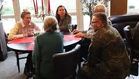 Ein Soldat und eine Zivilangestellte des Familienbetreuungszentrum Saarlouis im Gespräch mit Angehörigen von Soldaten