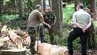 Ein General spricht Soldaten und einem Förster in einem Wald