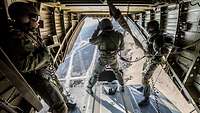 Der Bordschütze auf der Ladermpe der CH-53 ist mit speziellen Gurten gesichert