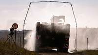 Ein GTK Boxer fährt durch eine Dekontaminationswaschanlage