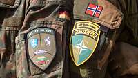 Nahaufnahme von zwei Patches der Battlegroup eFP an der Uniform eines Deutschen und eines norwegischen Soldaten
