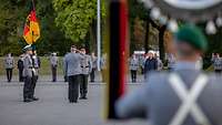 Lambrecht und Zorn befinden sich auf einem Appellplatz, um ihnen herum stehen Soldaten im "stillgestanden". 