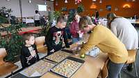 Kinder verzieren ihre gebackenen Plätzchen 