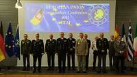 Servicewomen and men in front of a screen at the "EU Commanders' Conference 2021" in Ulm.