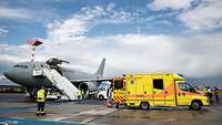 In the background a Bundeswehr aircraft and in the foreground an ambulance
