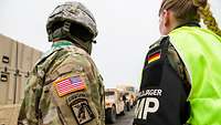 A rear view of a German female soldier and an American soldier