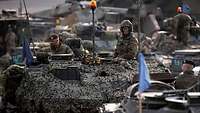 Soldiers sit on their combat vehicles