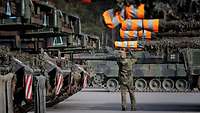 A soldier attaches a marker to a tank gun