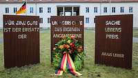 Der Erinnerungskranz liegt vor den Stelen auf dem Boden