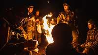 Soldaten sitzten am Feuer bei Nacht