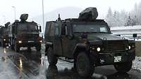 Fahrzeuge der Bundeswehr sind auf österreichischen Straßen unterwegs.