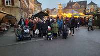 Gruppenfoto von den Teilnehmern vor dem beleuchteten Weihnachtsmarkt.