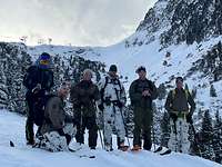 Eine Gruppe von Soldatinnen und Soldaten stehen auf Skiern vor einem Bergmassiv. Im Hintergrund eine Seilbahn.