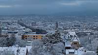 Schneebedeckte Skyline von Wiesbaden mit verschneiten Bäumen und Gebäuden 