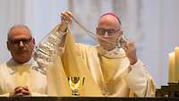 Bischof Dr. Franz Jung bereitet am Altar die Eucharistiefeier vor