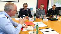 Der Generalinspekteur sitzt am Besprechungstisch mit Teilnehmern des LGAN 2021 und deren Lehrgangsleiter Oberst Dirk S. 