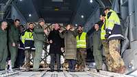 Boris Pistorius und Nancy Faeser stehen mit vielen Soldaten im Laderaum eines A400M.