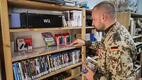 Ein Soldat steht vor einem Regal mit vielen Videospielen.