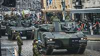 Mehrere estnische Schützenpanzer fahren während der Parade durch die Stadt.